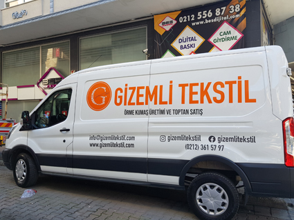 Gizemli Tekstil kurumsal kimlikli panelvan araç kaplama, turuncu cast folyo yazı ve iletişim bilgileri içeren profesyonel araç reklamı.